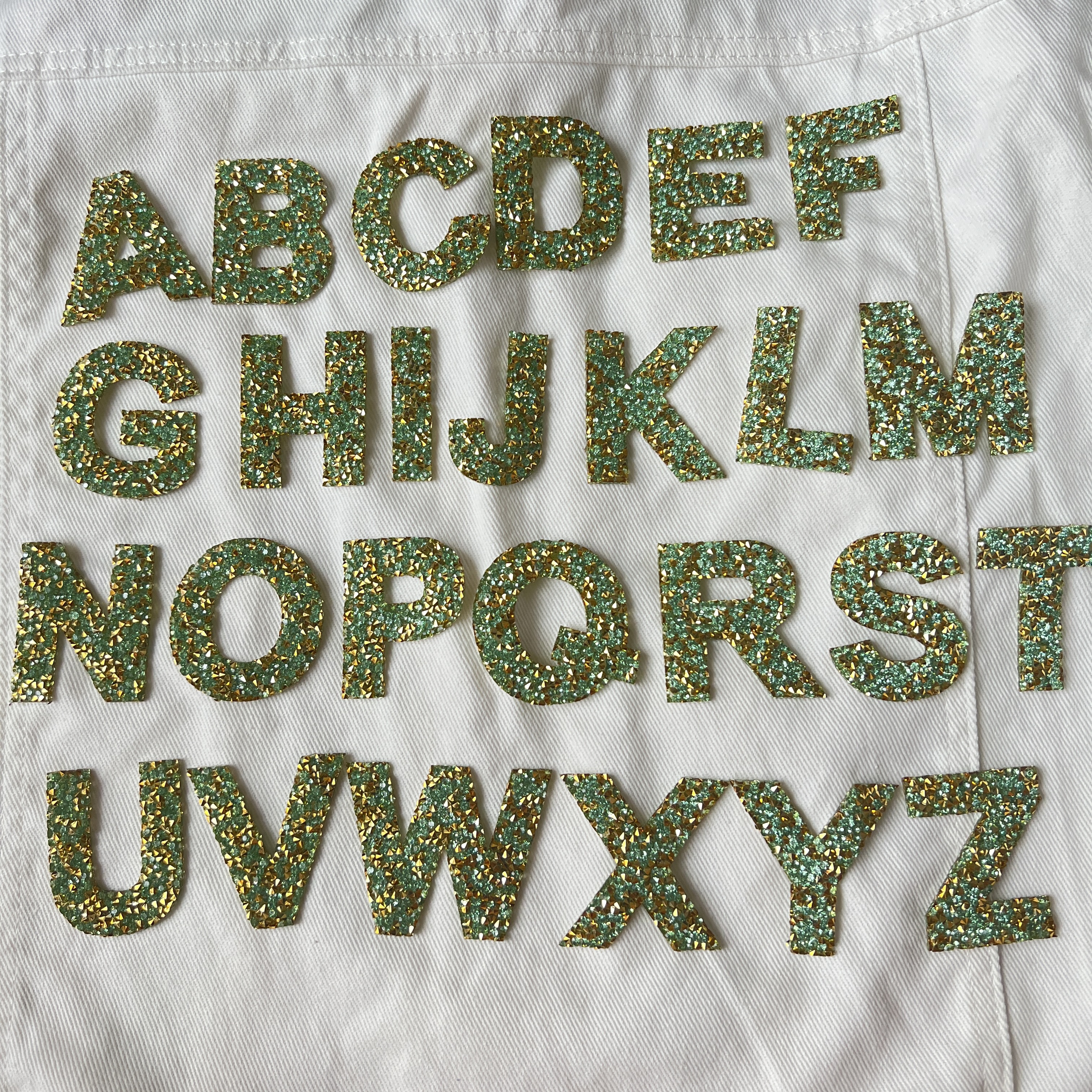 ตัวอักษร สีฟ้าทะเล ฟ้าอมเขียว เพชรวิบวับ คริสตัล ตัวรีดติดเสื้อ ตัวรีด ติดกระเป๋า ติดหมวก ติดแจ๊คเก็ต อักษรภาษาอังกฤษ Alphabet Patch